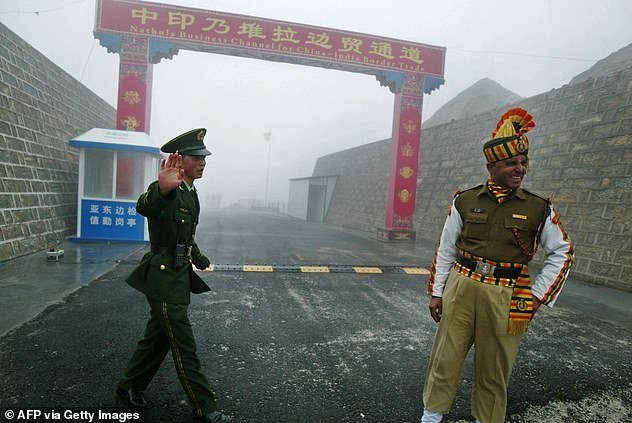 29215970-8543727-A_Chinese_soldier_left_and_an_Indian_soldier_stand_guard_right_a-a-19_1595375600140.jpg,0