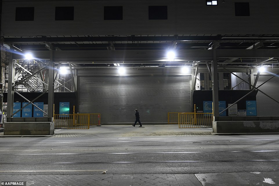 A lone Melburnian walks along Swanston Street, one of the main thoroughfares of the Melbourne CBD, hours after a citywide curfew was introduced