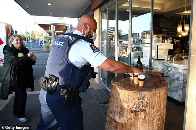 31880698-8626753-A_police_officer_wearing_a_mask_gets_his_morning_coffee_from_The-a-4_1597423131222.jpg,0