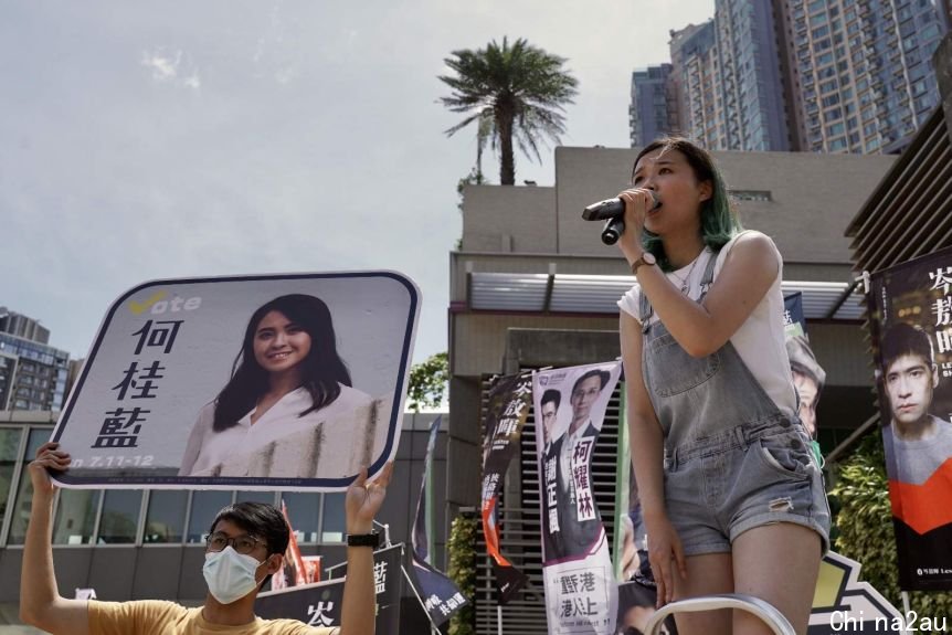 A woman using mic to speak in a public gathering in Hong Kong