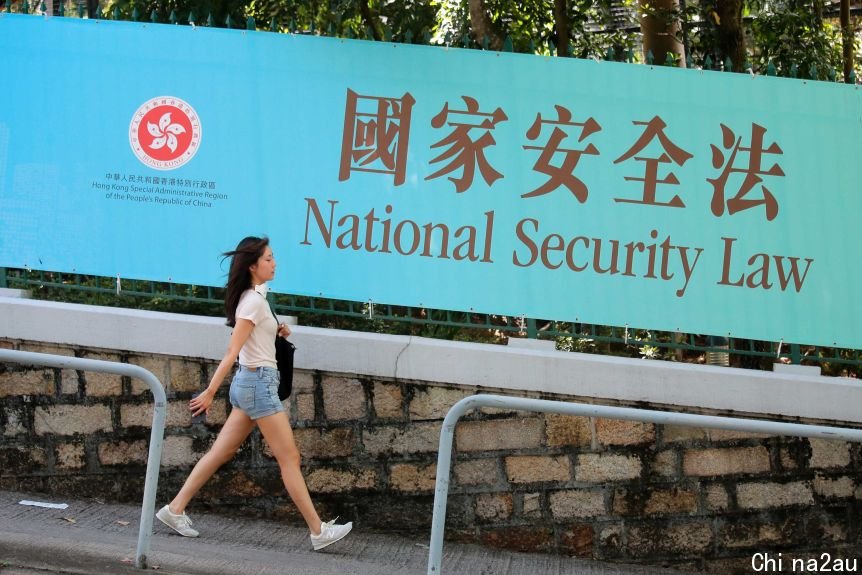 A woman walks past a promotional banner of the national security law for Hong Kong