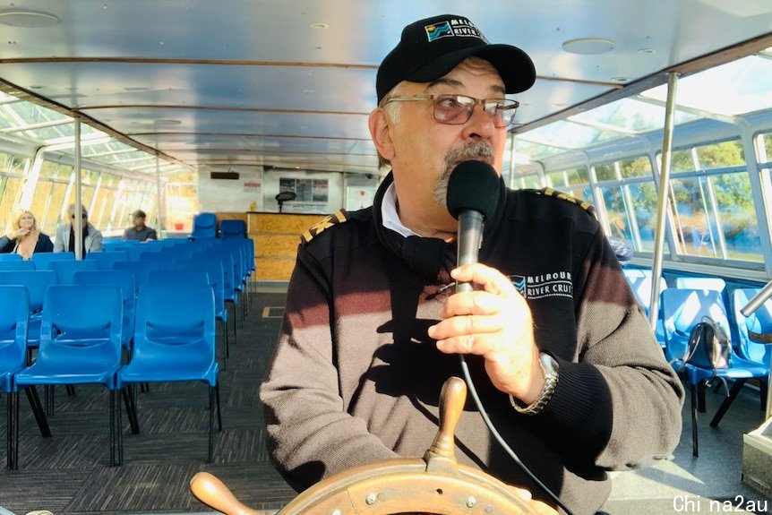 Captain Jimmy 'Whisker' steers the boat down the Yarra River in Melbourne.