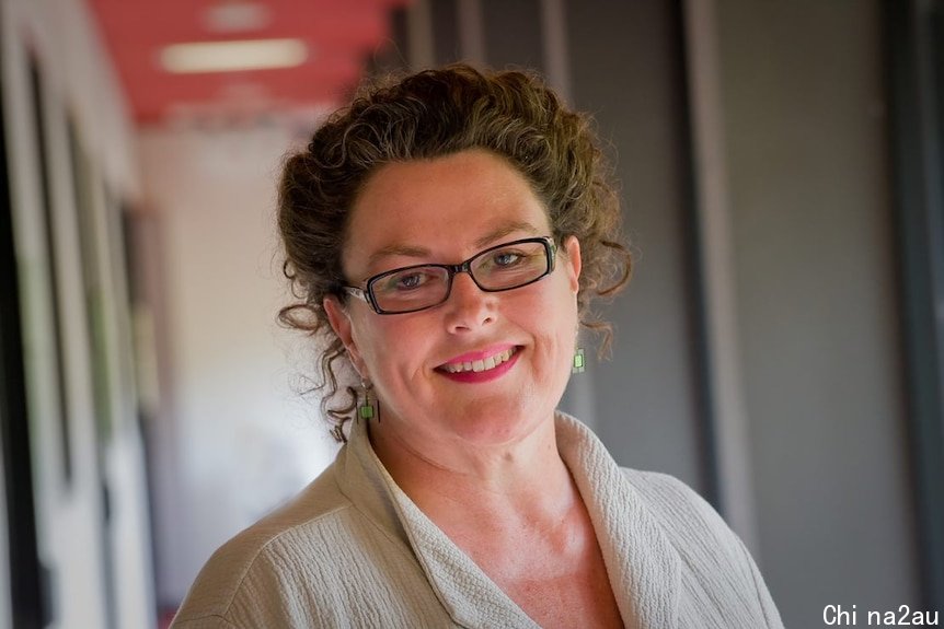 Portrait of a woman smiling at the camera with an out of focus background