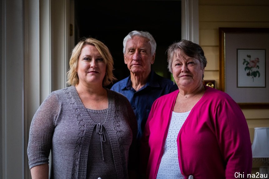 Karen Stewart, Brian Stewart and Val Stewart stand looking at the camera, neutral expressions on their faces.