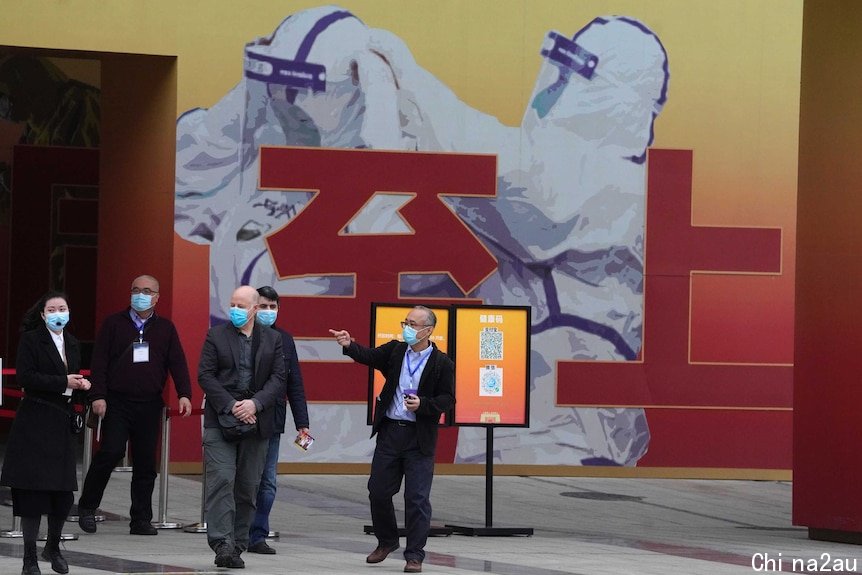 Members of the World Health Organization team leave after seeing an exhibition on COVID-19 in Wuhan.
