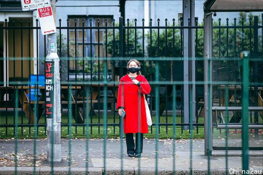 a woman standing by herself in a mask