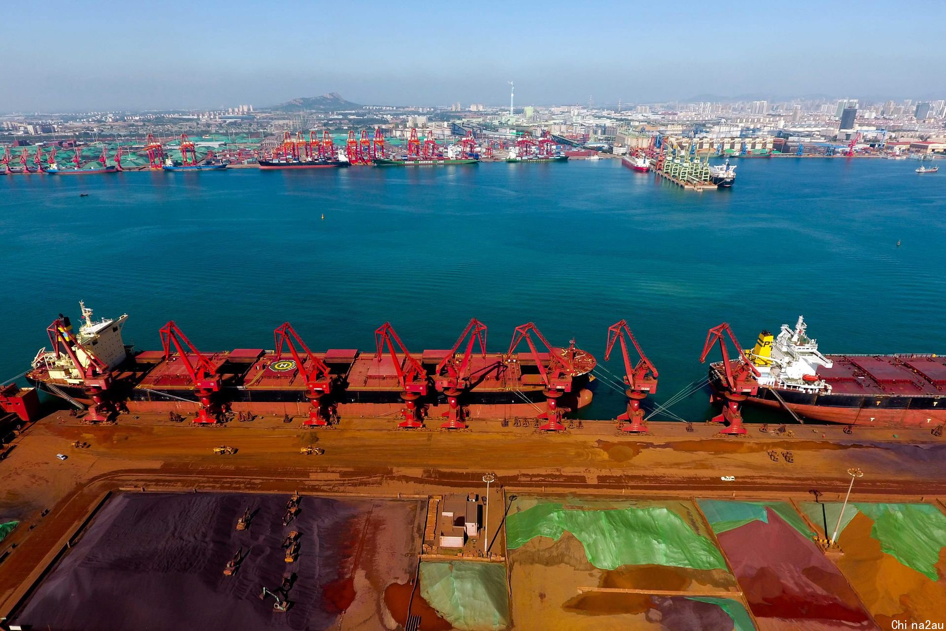 日照港三十万吨铁矿石码头，起重机在装载货物。（新华社）