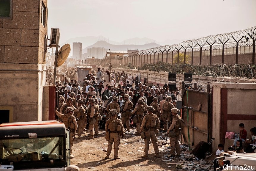 US soldiers stand in front of large crowds at Kabul airport