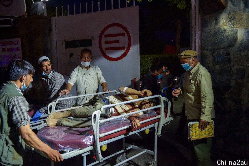 Hospital staff bring an injured man on a stretcher for treatment