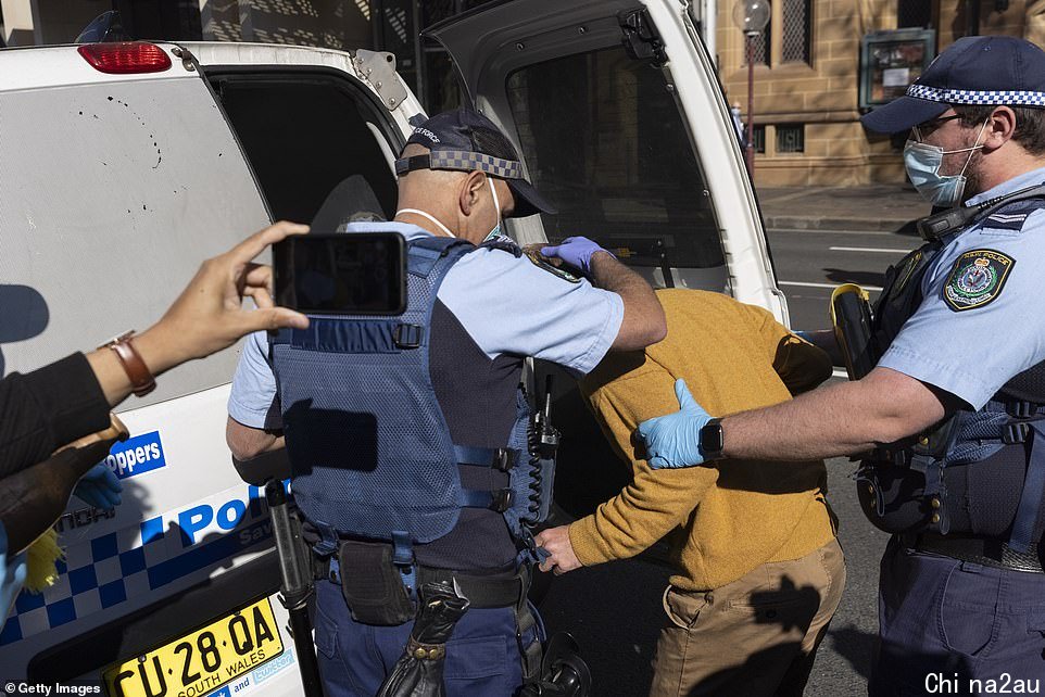 Police are seen taking away one protester during the silent demonstration in Sydney on Tuesday
