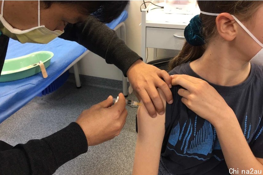A health practitioner administers a vaccine to a teenage girl.