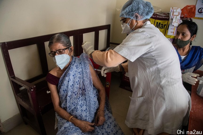 An elderly woman receives the AstraZeneca vaccine for COVID-19