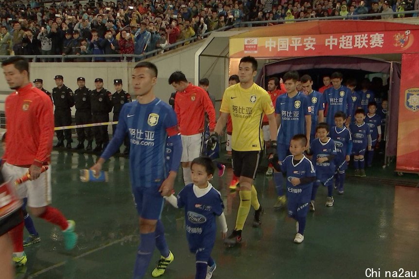 Players for Jiangsu Suning and Guangzhou Evergrande walk out during a Chinese Super League match in Nanjing, China.