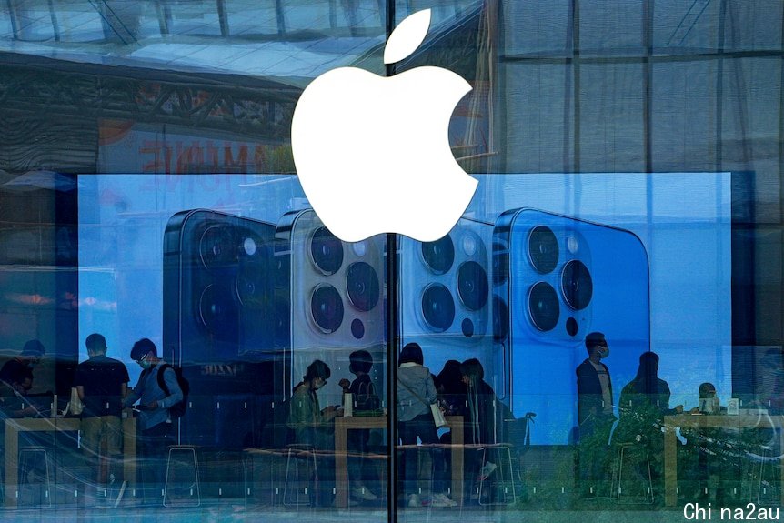 人们戴着口罩在北京一家苹果专卖店试用最新款的iPhone手机。