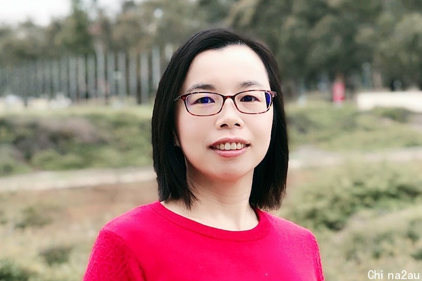 A photo of a woman with glasses and red jumper. 