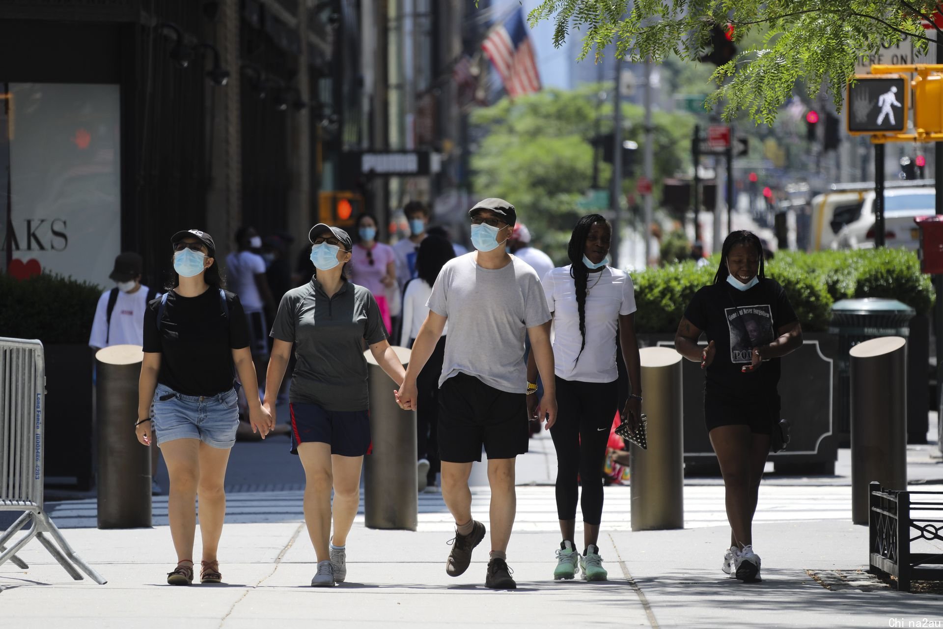 2021年7月4日，人们戴着口罩走在美国纽约第五大道。（新华社）