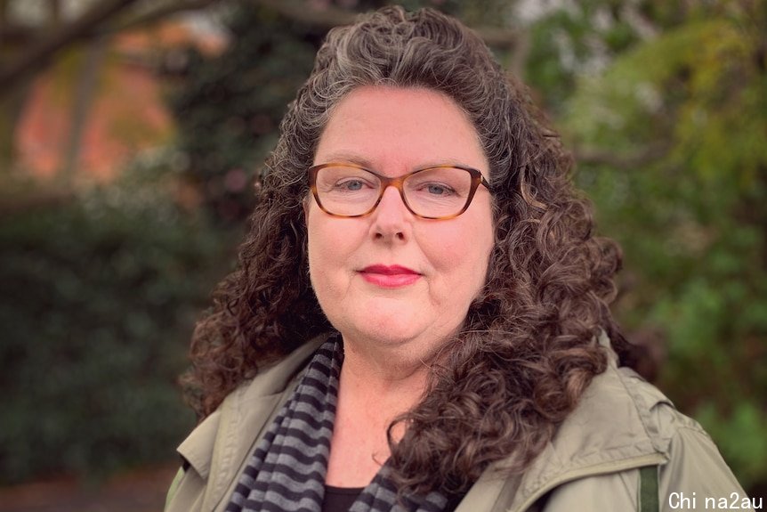 A woman in spectacles in a park.