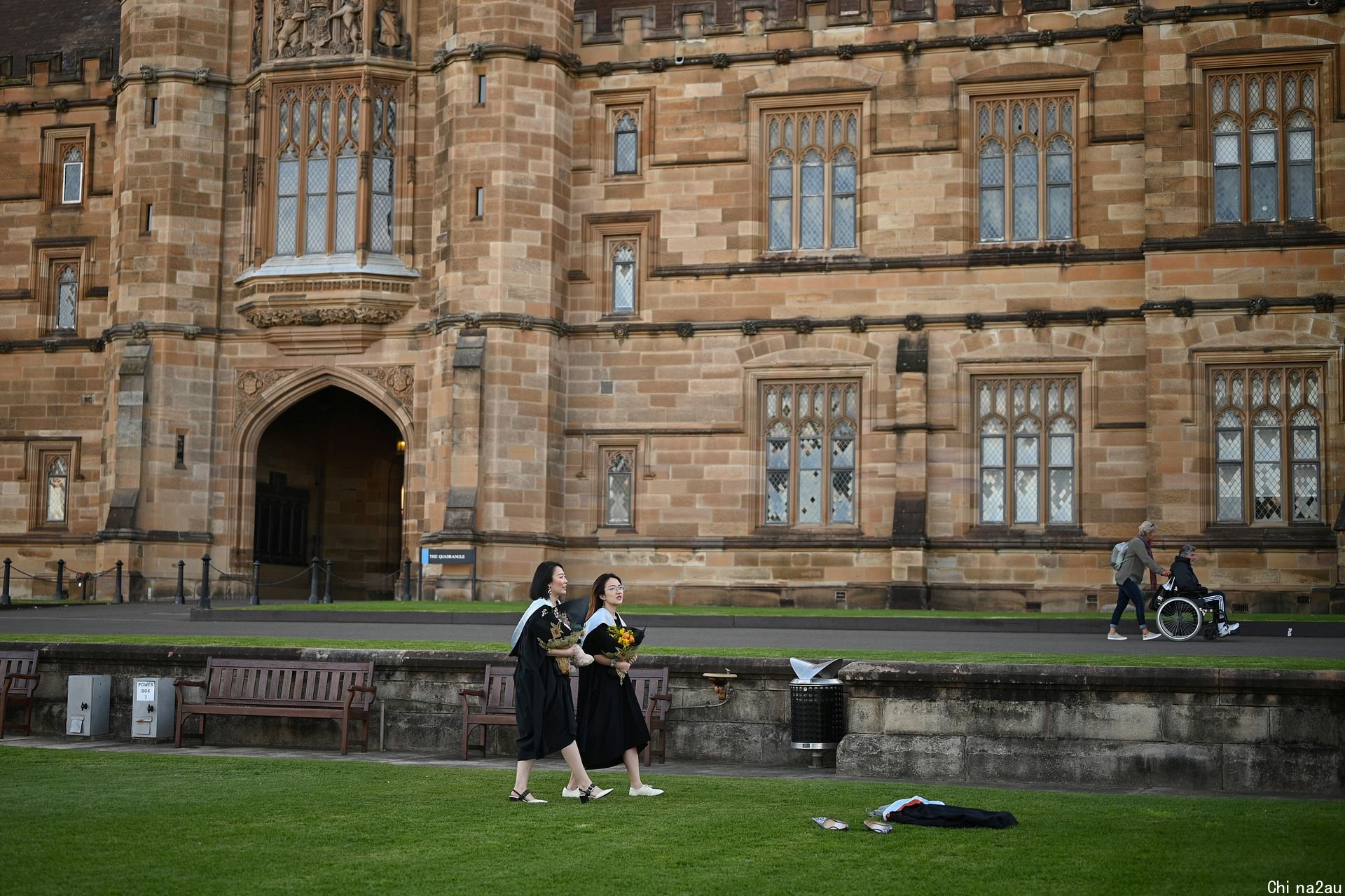 在面对面毕业典礼因新冠肺炎（COVID-19）疫情取消后，Shiyu Bao和同样来自中国的同学Katerina Ma穿着学位服在悉尼大学校园里拍照。（人民视觉）