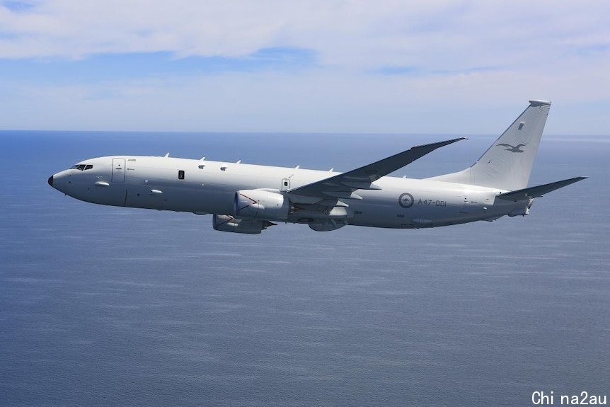 A side view of a P-8A Poseidon showing it fly above an ocean at day time 