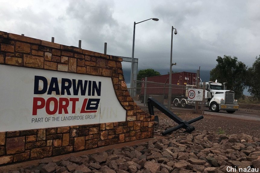 The exterior wall of Darwin Port with signage in red and white and a truck in the background.