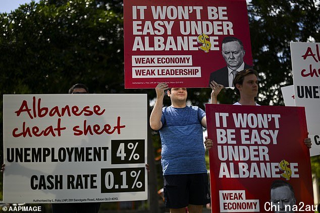 Labor critics are seen near where Australian Opposition Leader Anthony Albanese holds a press conference after inspecting a street affected by recent flooding