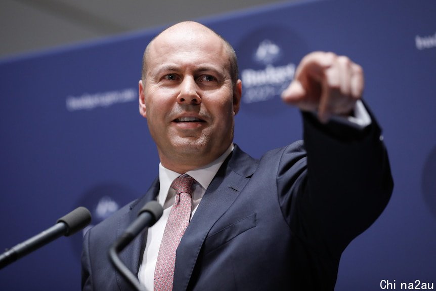 Josh Frydenberg points into the distance while holding a press conference