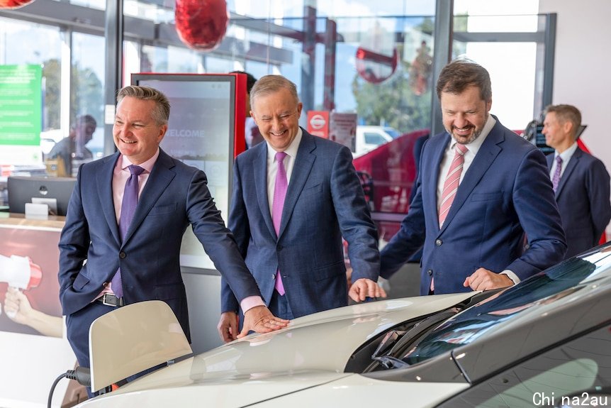 Labor's environmental spokesman Chris Bowen, Anthony Albanese and Labor MP Ed Husic check out a Nissan Leaf inside a showroom.