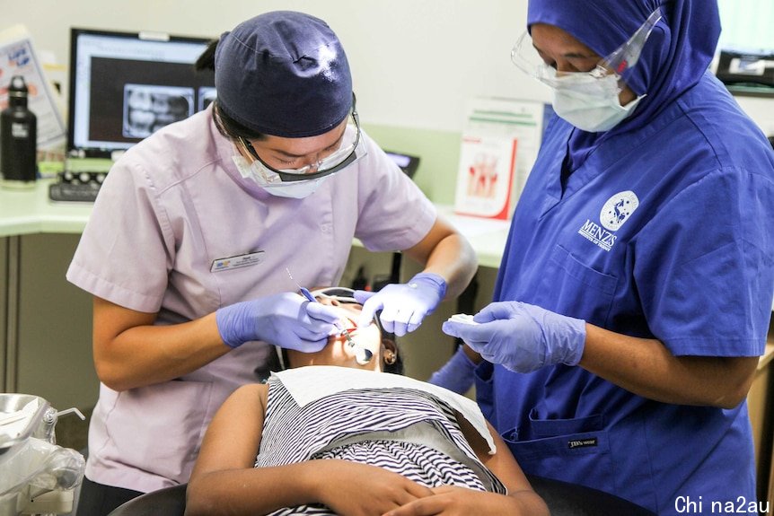 A dentist operates on a child.