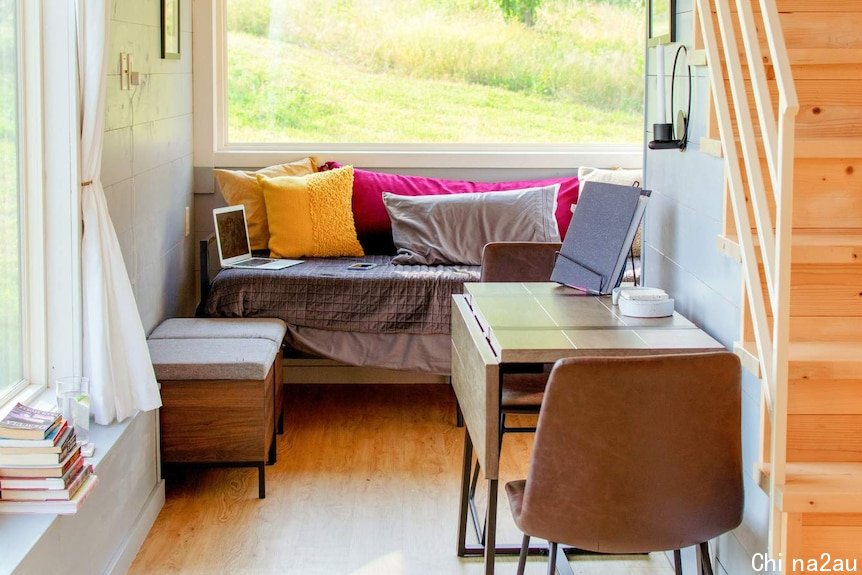 Interior of a tiny house, with stairs to the bedroom loft.