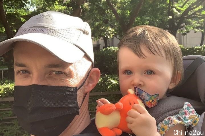 一名戴着口罩的男子和一个婴儿自拍