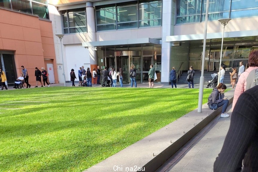 People lining up outside an official looking building