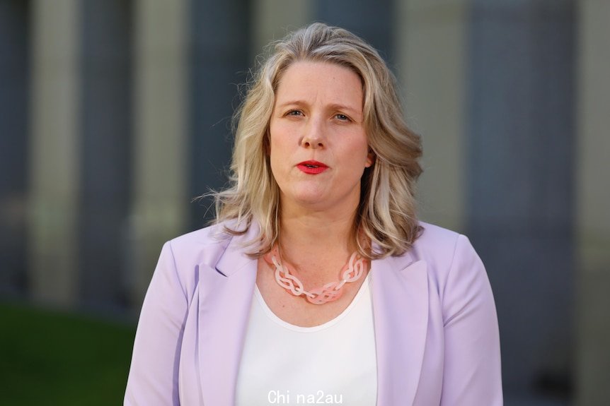 Clare O'Neil wearing a light purple blazer and pink necklace