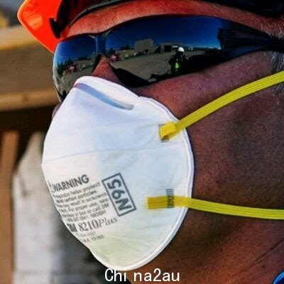 A man wearing a white face mask