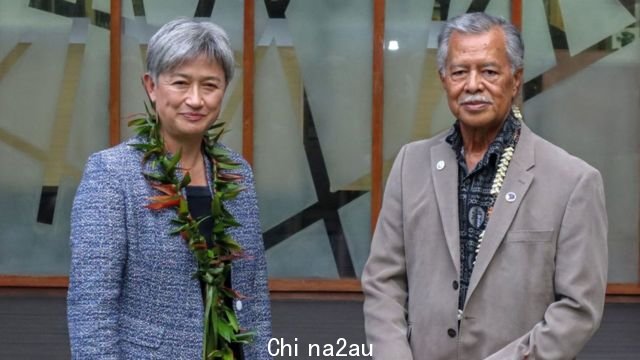 Penny Wong smiles beside Henry Puna, the Secretary General of the Pacific Island Forum