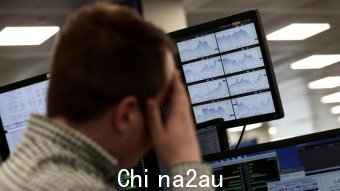 A trader looks at financial information on computer screens on the IG Index the trading floor in London