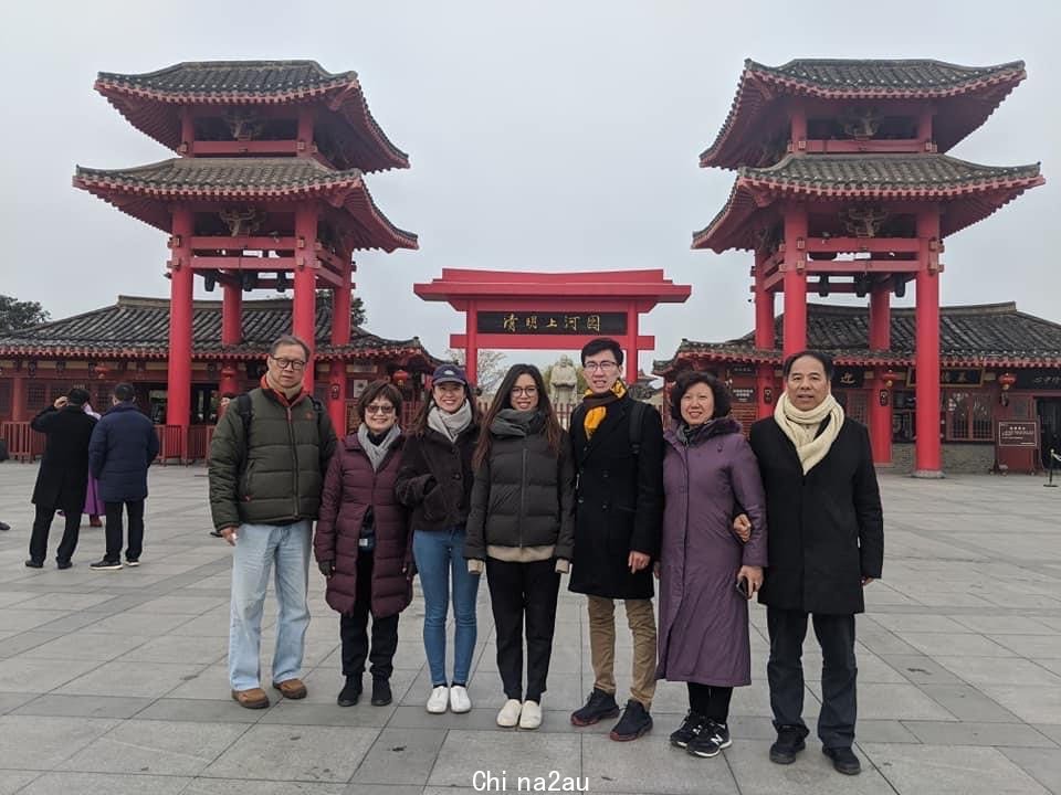 Jack Lu and his parents standing in front of a traditional Chinese building. 