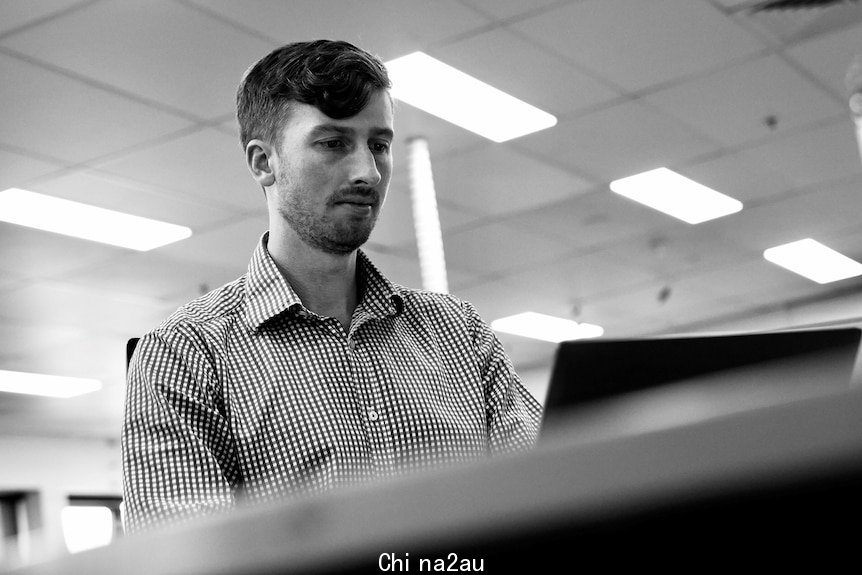 Patrick at his computer at his work office. 