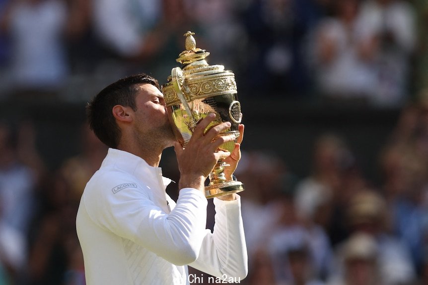 Novak Djokovic kisses the Wimbledon trophy