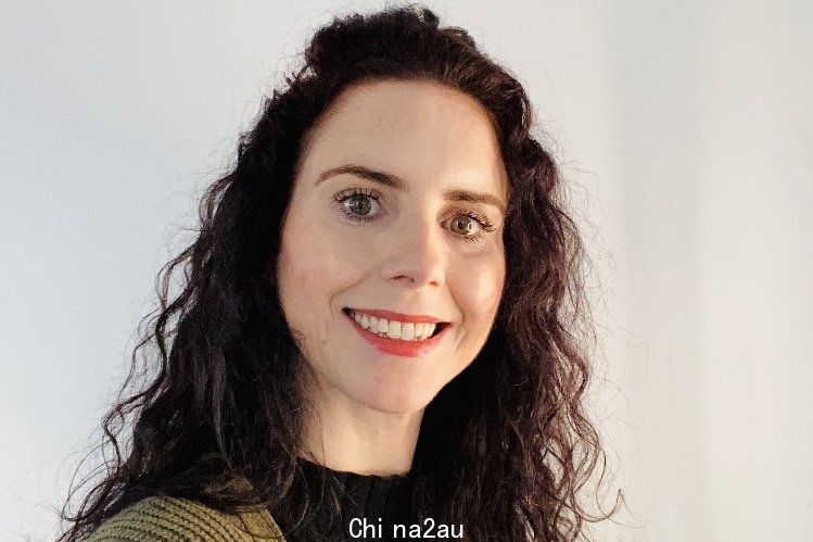 A close up profile image of kerry north with dark curly hair, hazel eyes, light shining on face in front of white background