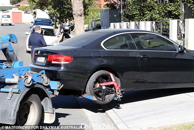 A black BMW coupe covered in dust was removed from the garage of the apartment block