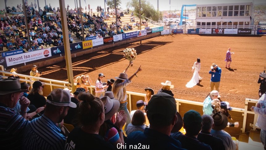 A shot of the bouquet toss taken from the crowd.
