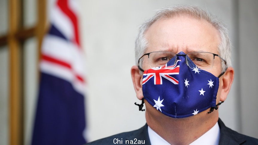 Tight shot of Morrison is staring straight ahead wearing a mask with the Australian flag on it.