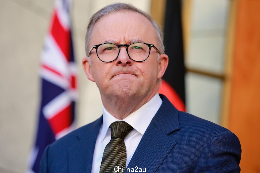Anthony Albanese frowns while speaking at a press conference outside his office
