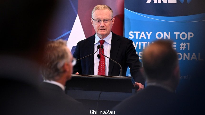 A man in a suit stands behind a podium. 