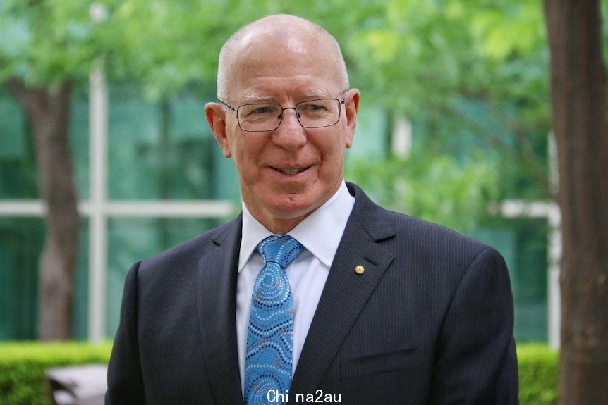 Governor Hurley smiles as he poses for photos in one of the courtyards of Parliament House in Canberra.