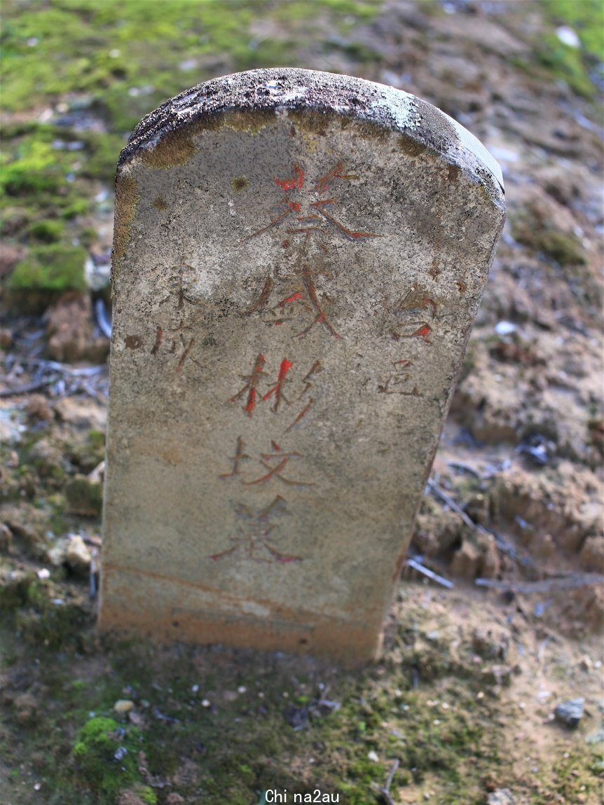 A grey tombstone with chinese inscription. 