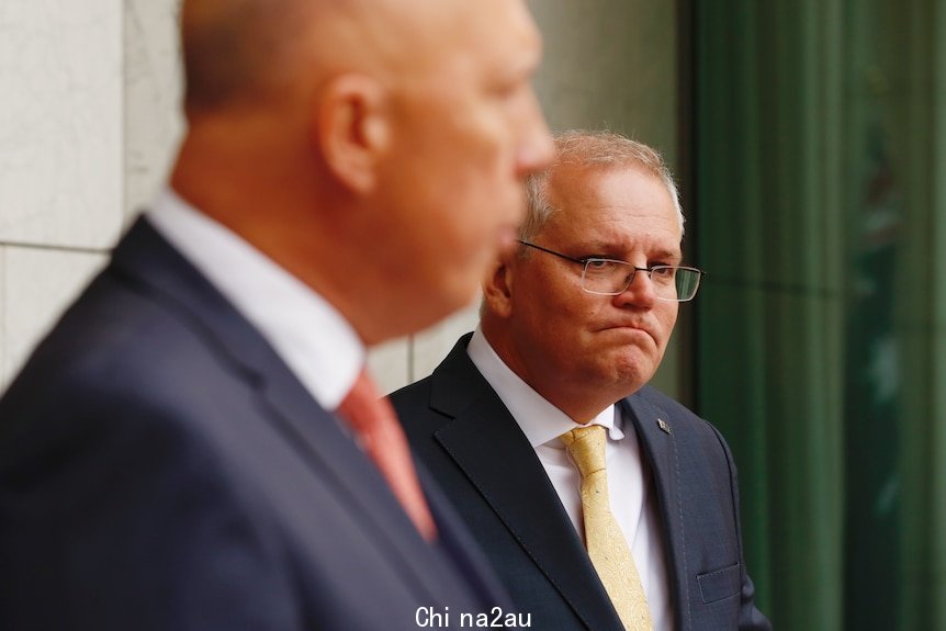 Scott Morrison watches Peter Dutton at a joint press confernece