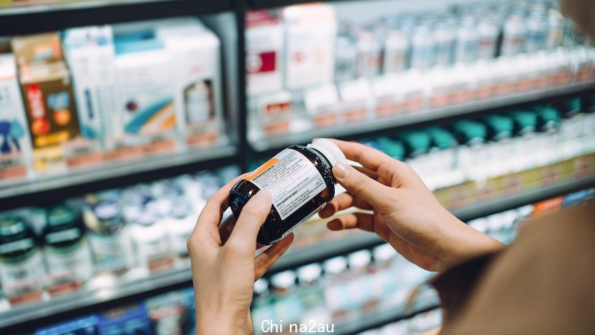 Woman reading the label on a bottle of vitamins 