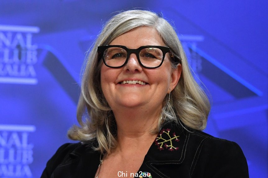 a woman wearing glasses smiling