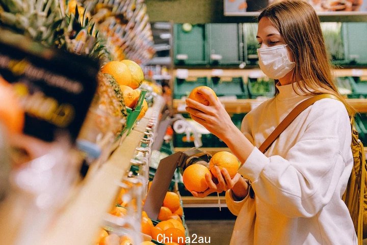 A woman is choosing fruits at supermarket.